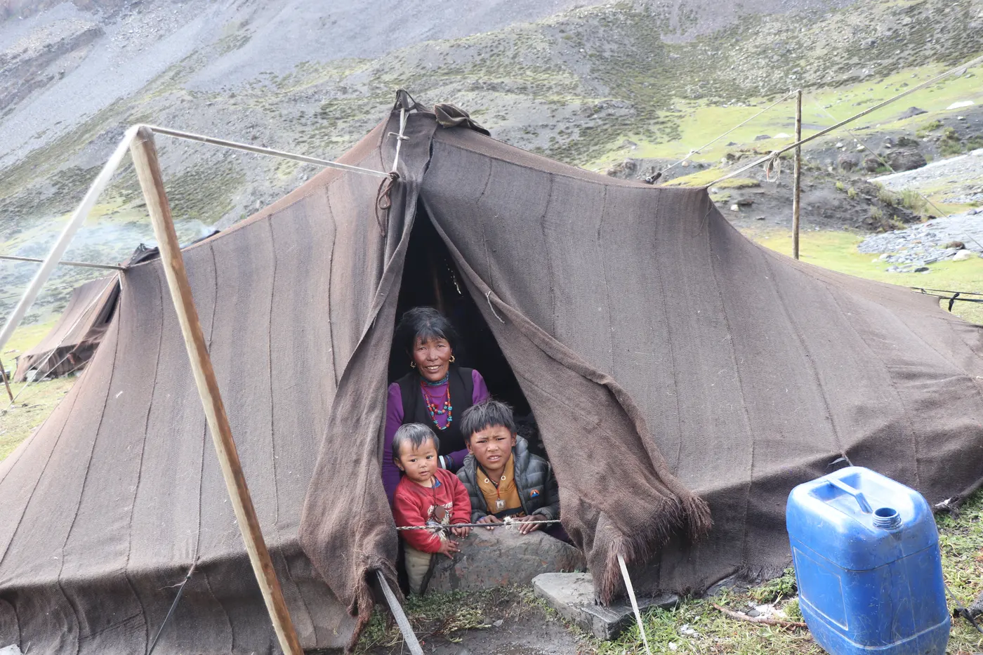 A mother and children gathered at a tent in a remote Himalayan community